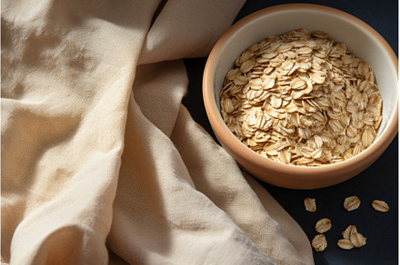Bowl with oatmeal flakes on fabric, a Food & Drink Photo by Ylivdesign
