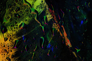 Abstract close-up of wet glass with glowing yellow, green, and r, a Background Photo by Ales Munt