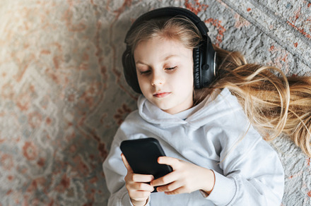 Little girl listening music lying on the floor, a Person Photo by Olena Rudo