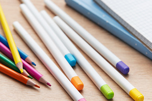 Colorful pencils and school supplies on wooden table