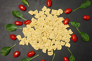 Uncooked tortellini pasta with fresh cherry tomatoes and spinach, a Food & Drink Photo by ndanko