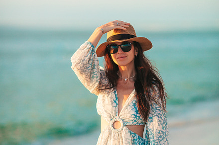 Young beautiful woman at straw hat on the beach at sunset, a Person Photo by travnikovstudio