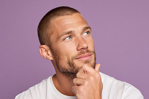 Thoughtful young man against purple background, a Person Photo by AlyaAnd