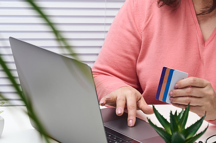 woman in a pink sweater makes purchases online with a laptop, a, a Business Photo by ndanko
