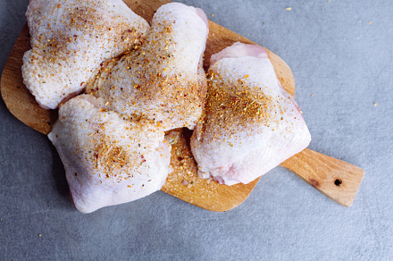 Raw chicken thigh with herbs featuring background, bird, and board