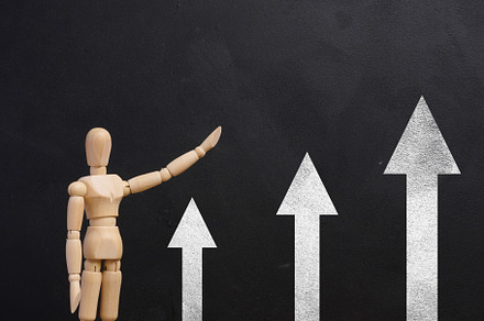 Wooden mannequin points at black chalk board with arrows, growth, a Business Photo by ndanko