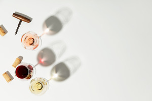 Flat-lay of red, rose and white wine in glasses on white backgro, a Food & Drink Photo by Natalia Klenova's Shop