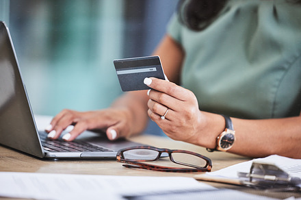 Online shopping, credit card and woman hands with laptop for ecommerce, payment and purchase on internet store. Technology, fintech and girl typing banking details on computer for online banking, a Photo by Peopleimages.com