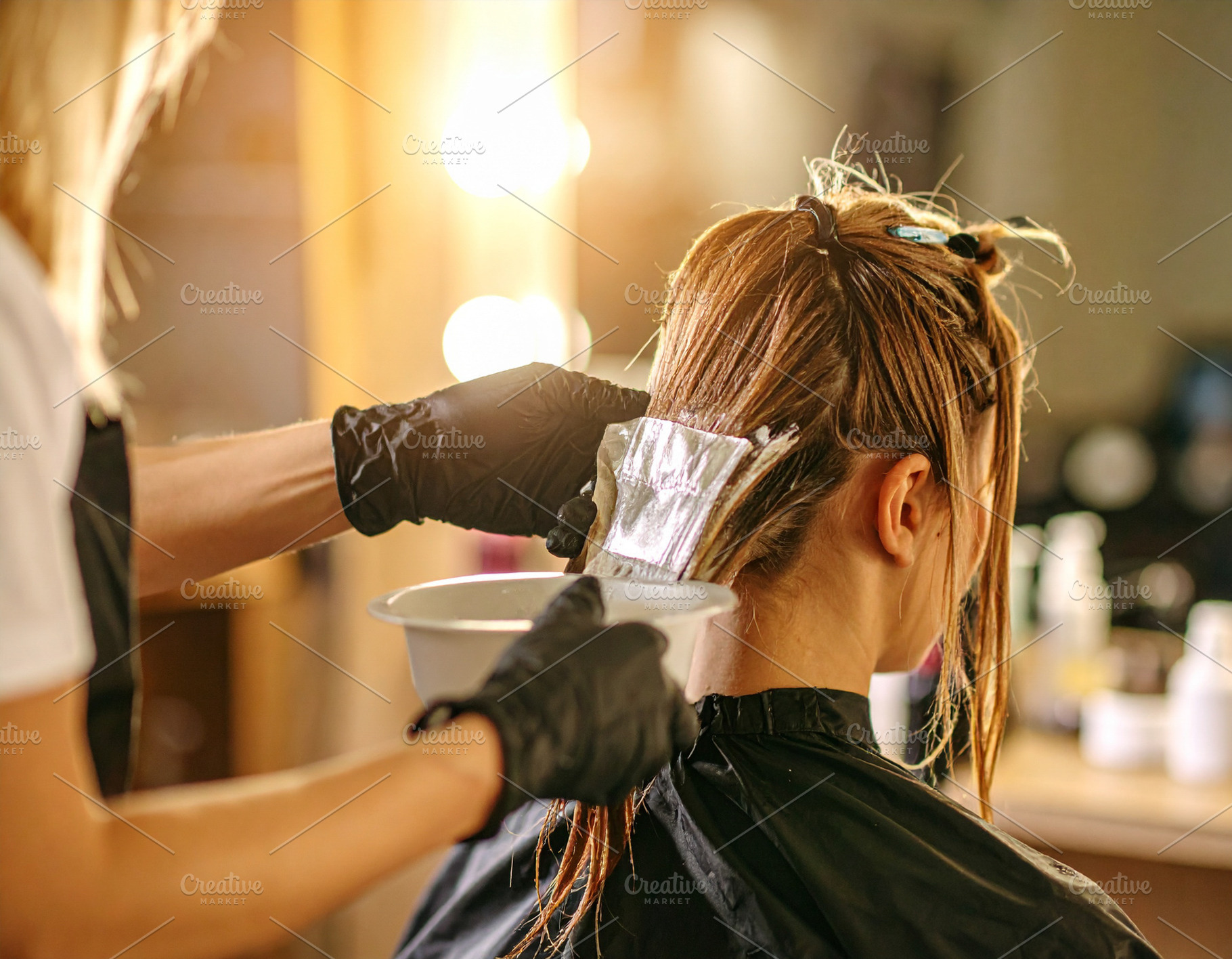 Single stylists hands applying hair color to a client’s hair s, a Beauty & Fashion Photo by DanFLCreativo
