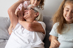 Grandmother playing and laughing with her granddaughters at home, a Person Photo by etorres69
