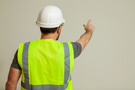 worker in a vest and white helmet, a Person Photo by Photostock