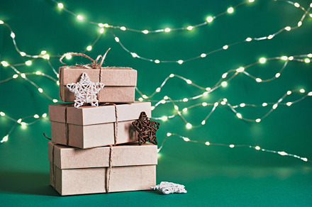 Christmas sustainable gift boxes and shining garland on green background. Chris, a Holiday Photo by colnihko