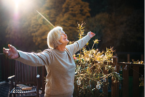 Senior woman enjoying warm autumn, a Nature Photo by HalfPoint