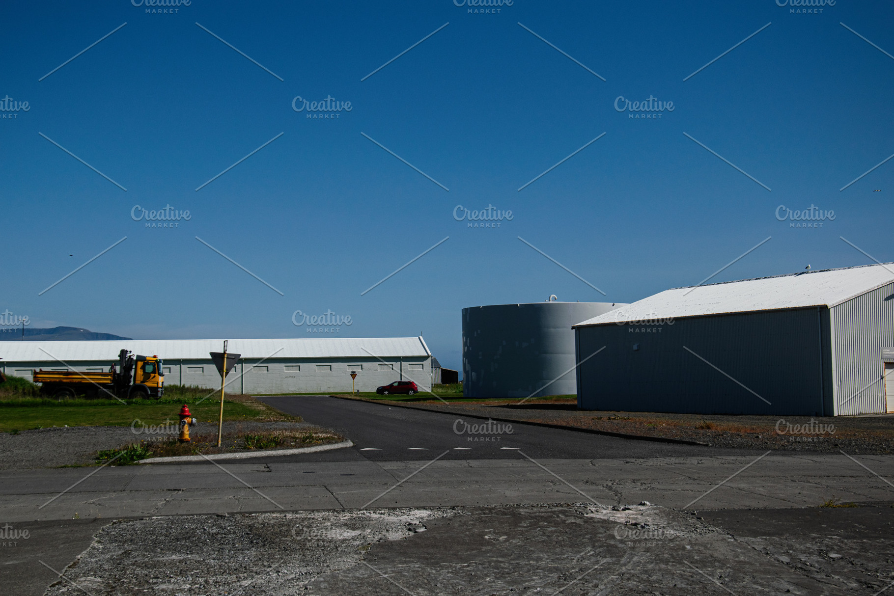 Industrial area with buildings and blue sky in Akranes, Iceland, a Photo by AS photostudio