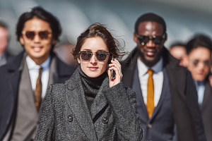 Stylish business traveler leads group of colleagues through busy urban city str, a Photo by AS photostudio