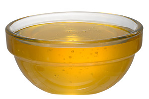 Golden honey in glass bowl on isolated background, a Food & Drink Photo by ndanko