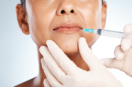 Injection, plastic surgery and lip filler on woman face for cosmetics, collagen and beauty salon. Skincare, facial needle and botox aesthetic, liposuction and body transformation on studio background, a Photo by Peopleimages.com