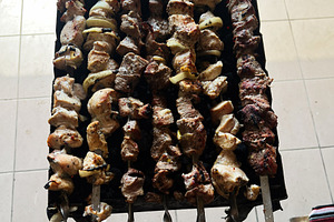 Grilled meat skewers arranged neatly on skewers over a hot barbecue grill, a Photo by AS photostudio