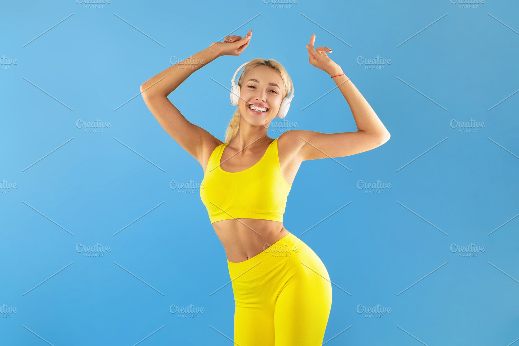 Smiling Young Woman In Sportswear Listening To Music And Dancing, a Photo by Prostock-Studio