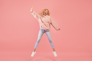 Expressing joy and happiness. Full length shot of active young woman jumping an, a Photo by Prostock-Studio