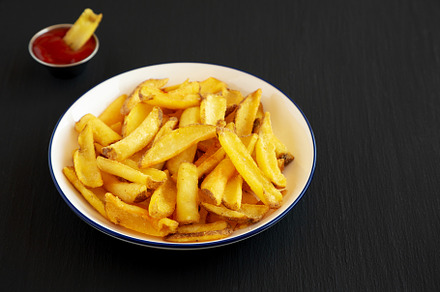 Homemade French Fries on a Plate on a black background, side vie, a Food & Drink Photo by LiudmylaChuhunova