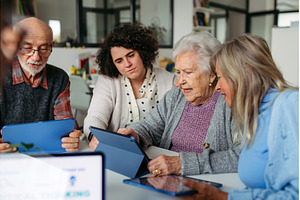 Tutor teaching seniors about phone, a Technology Photo by HalfPoint