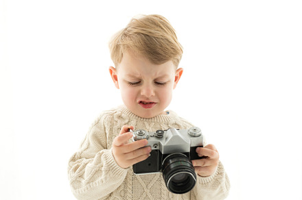 A little boy with a camera in his ha
