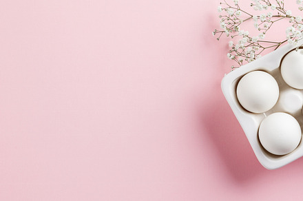 Easter concept. White eggs in ceramic holder and flowers on pink, a Holiday Photo by Natalia Klenova's Shop