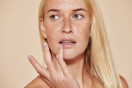 Woman with freckles touching her lip, a Beauty & Fashion Photo by Artem Varnitsin