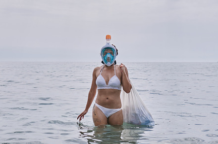a young girl with diving goggles pulling trash out of the ocean, a Holiday Photo by YossSabalet