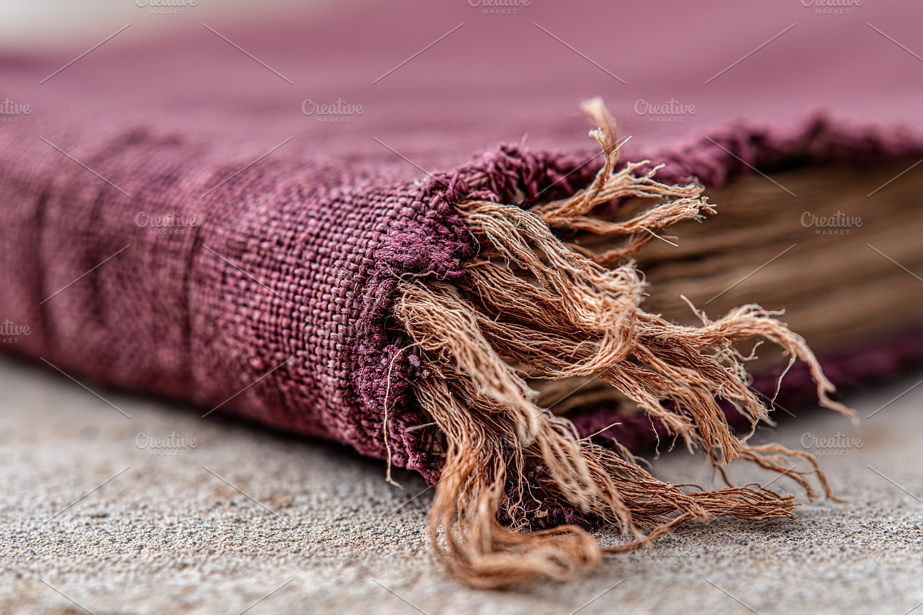 Detailed view of an aged book cover with frayed edges resting on a surface, a Photo by AlyaAnd