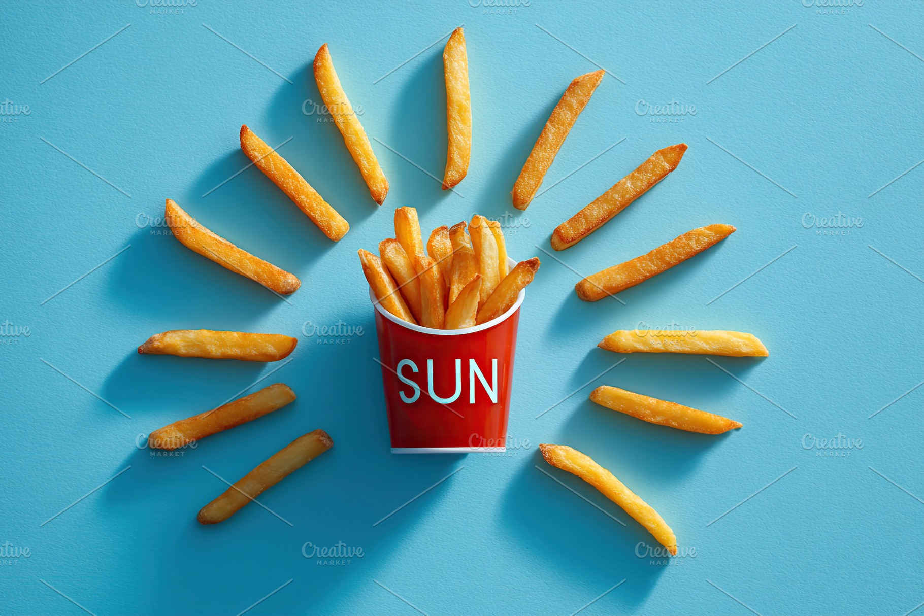 Fries artfully arranged to resemble sun rays around a red cup labeled sun, a Food & Drink Photo by AlyaAnd