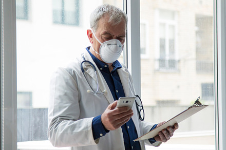 Doctor with mask using mobile phone containing coronavirus, health, and doctor