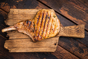 Tender grilled Tomahawk pork chop, showcasing its rich marbling, a Food & Drink Photo by composter-box@mail.ru