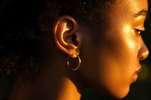 A gold hoop earring on a womans ear, a Photo by Pavel_design