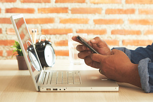 Businessman using laptop and mobile phone