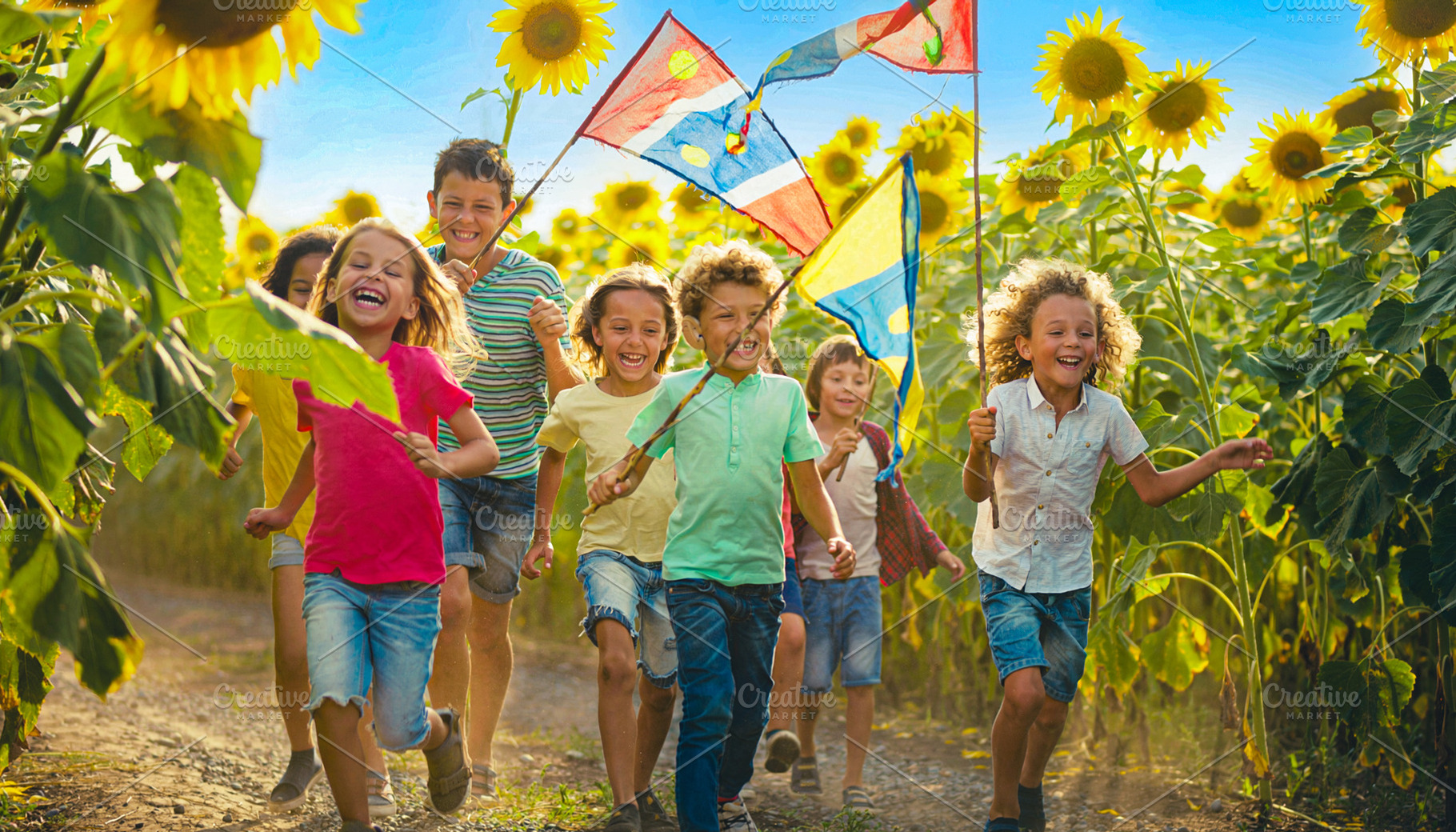 Group of children running through a sunflower field, a Person Photo by DanFLCreativo