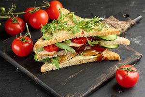 Grilled chicken sandwich with fresh tomatoes, cucumbers, arugula, a Food & Drink Photo by ndanko
