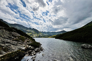 Scenic mountain lake in Zakopane Poland with rocky shore and dramatic clouds, a Nature Photo by AS photostudio