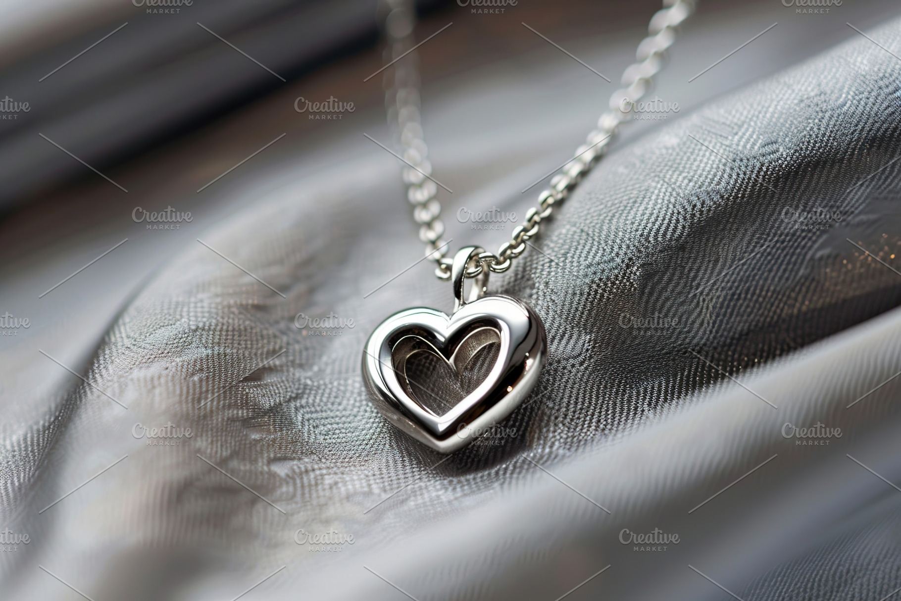 Silver heart pendant and chain on grey background, a Photo by AlyaAnd