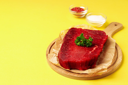 Concept of tasty food with with raw beef steak on yellow backgro, a Food & Drink Photo by AtlasStudio PRO