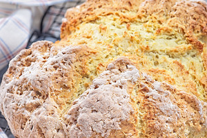 Freshly baked soda bread on cooling rack with butter and honey in the backgroun, a Food & Drink Photo by iuliia_n