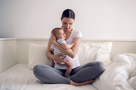 Mother with her newborn son in hands featuring baby, bed, and boy, a Person Photo by SaulichPhoto