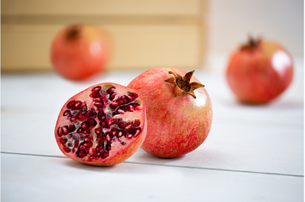 Fresh pomegranate lying on the white, a Food & Drink Photo by WildMedia