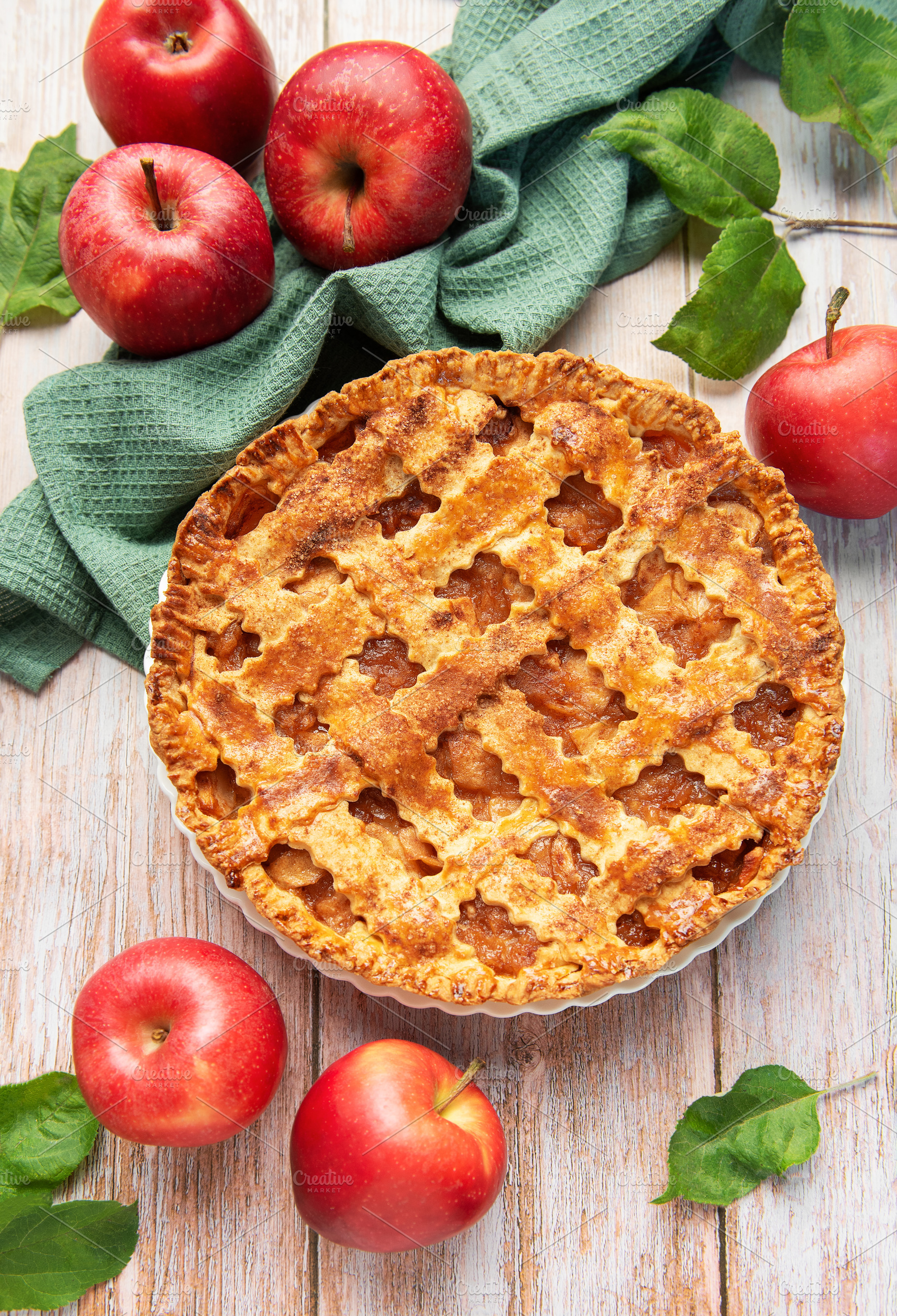 Freshly baked apple pie surrounded by ripe red apples and green, a Food & Drink Photo by Olena Rudo