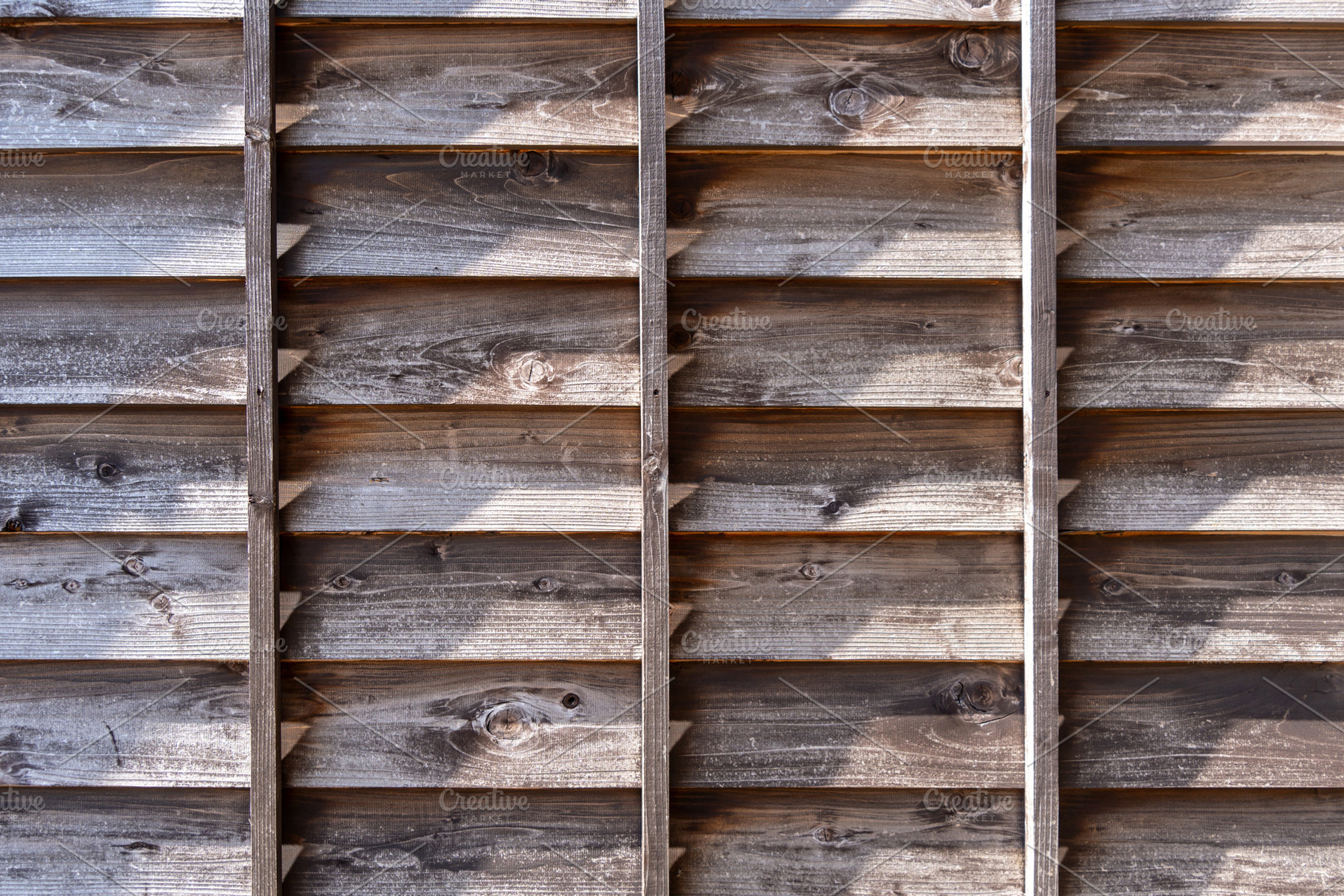 Old wooden fence with shadows and aged texture details, an Architecture Photo by GoodGoods