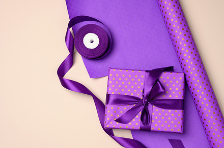 gift boxes tied with purple silk ribbon on an beige background,, a Holiday Photo by ndanko