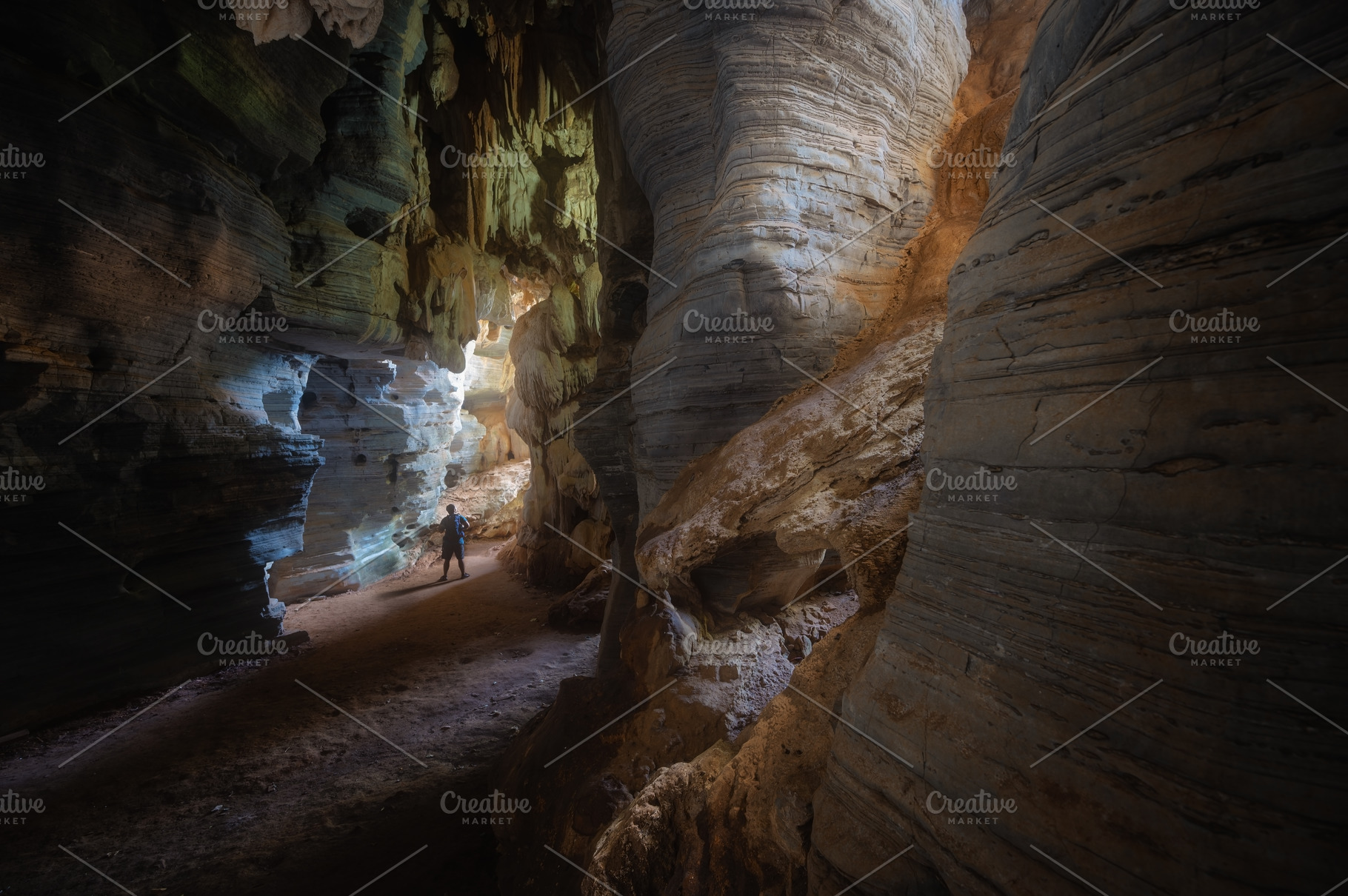 Man exploring the cave in Tam See Fah or Blue cave in Tak provin, a Photo by KHphotography
