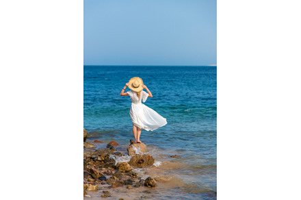 A woman in a hat looks at the sea, a Nature Photo by yanadjana