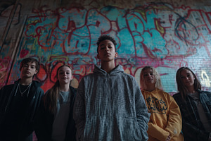 A group of five young people standing confidently in front of a colorful graffi, a Person Photo by Textures & Backgrounds